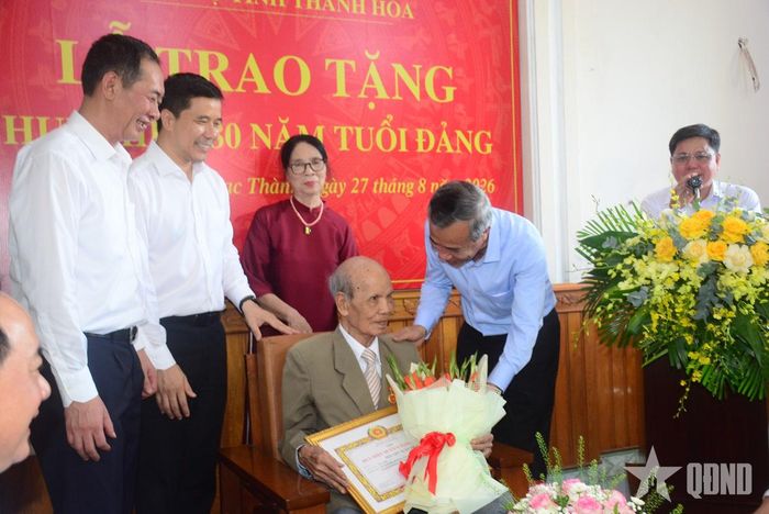 Đại diện Ban Thường vụ Tỉnh ủy Thanh Hóa trao quà tặng đảng viên lão thành Nguyễn Xuân Trớc.