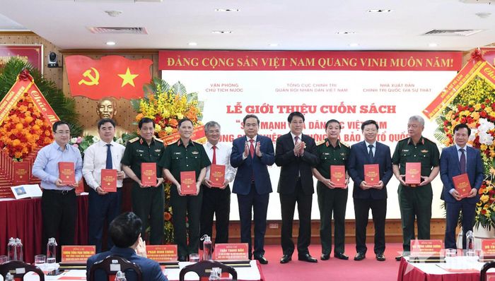 Đại tướng Lương Cường, nguyên Chủ tịch nước và Chủ tịch Quốc hội Trần Thanh Mẫn trao sách tặng các đại biểu. 