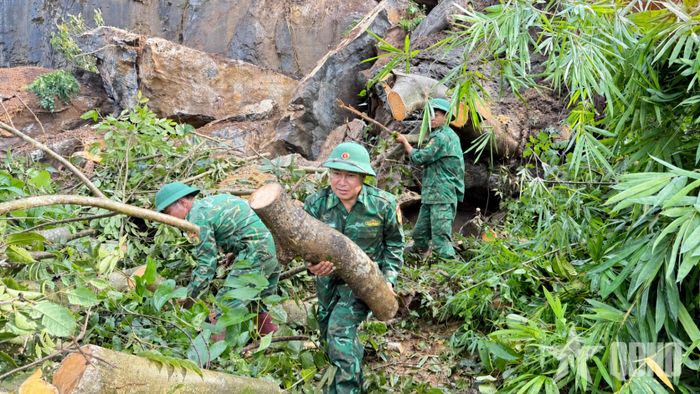 Cán bộ, chiến sĩ Đồn Biên phòng Chiềng Tương (Ban chỉ huy Bộ đội Biên phòng tỉnh Sơn La) dọn dẹp đất đá, cây cối đổ chắn đường. Ảnh: QUÀNG HÙNG
