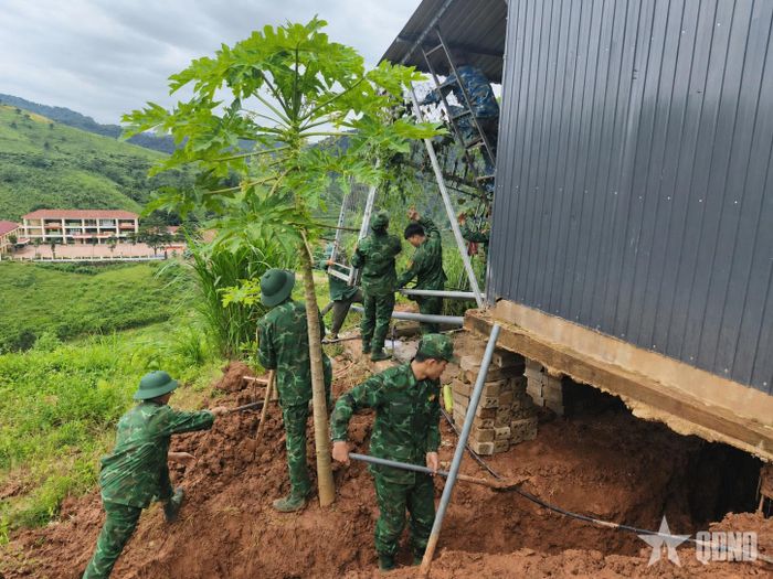 Cán bộ, chiến sĩ Đồn Biên phòng Cửa khẩu quốc tế Lóng Sập (Ban chỉ huy Bộ đội Biên phòng tỉnh Sơn La) giúp hộ dân tại bản Bó Sập (xã Lóng Sập) khắc phục hậu quả sạt lở đất. Ảnh: QUÀNG HÙNG