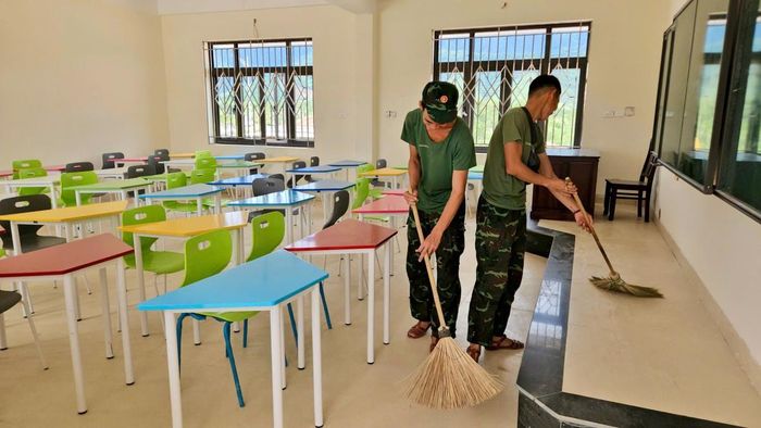 Các chiến sĩ lực lượng vũ trang đang hỗ trợ dọn dẹp tại công trình.