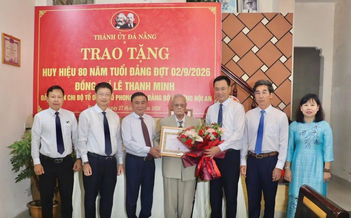 Thường trực Ban Bí thư Trần Cẩm Tú trao huy hiệu Đảng và chúc mừng đảng viên Lê Thanh Minh