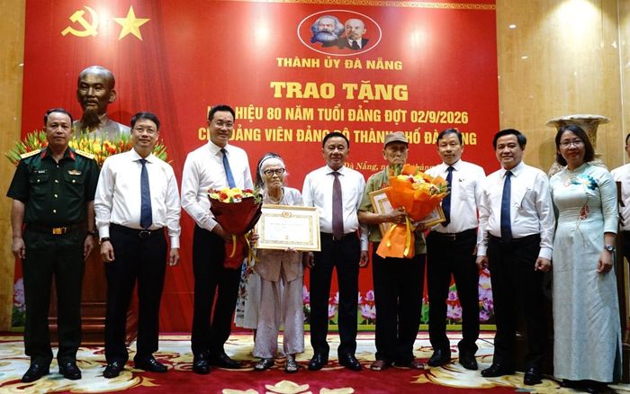Thường trực Ban Bí thư Trần Cẩm Tú (thứ 5, từ phải qua) trao huy hiệu đảng và chúc mừng các đảng viên