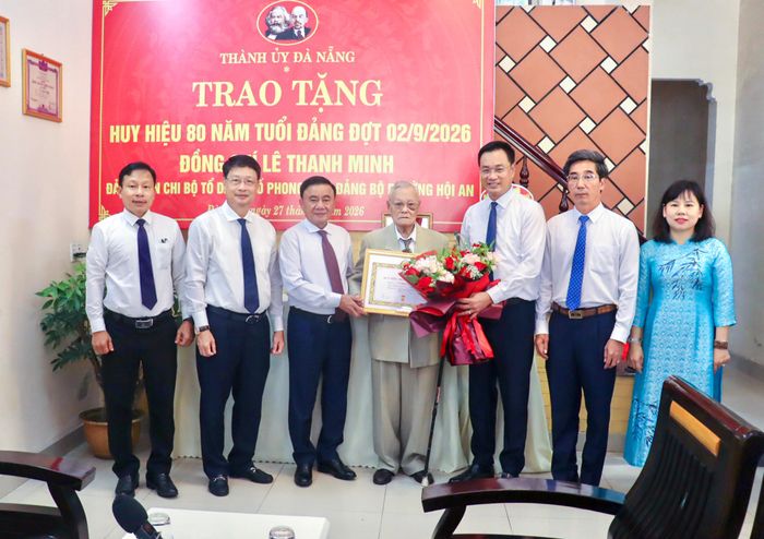 Thường trực Ban Bí thư Trần Cẩm Tú và Bí thư Thành ủy Đà Nẵng Lê Ngọc Quang trao Huy hiệu 80 năm tuổi Đảng, tặng hoa chúc mừng đảng viên Lê Thanh Minh. Ảnh: XUÂN QUỲNH