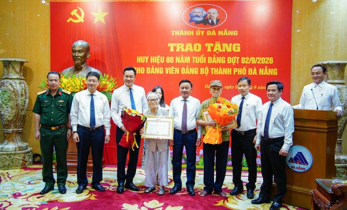 Thường trực Ban Bí thư Trần Cẩm Tú và Bí thư Thành ủy Đà Nẵng Lê Ngọc Quang trao Huy hiệu 80 năm tuổi Đảng, tặng hoa và chúc mừng các đảng viên. Ảnh: XUÂN QUỲNH