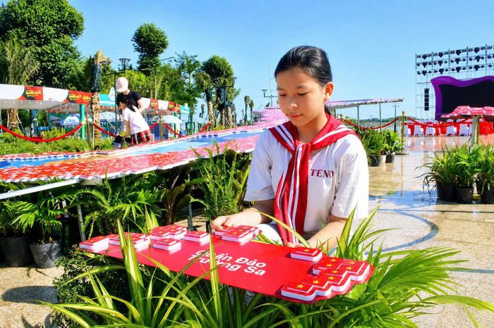  Một học sinh đến tham gia góp lá cờ Tổ quốc. Ảnh: NGUYỄN TRANG 