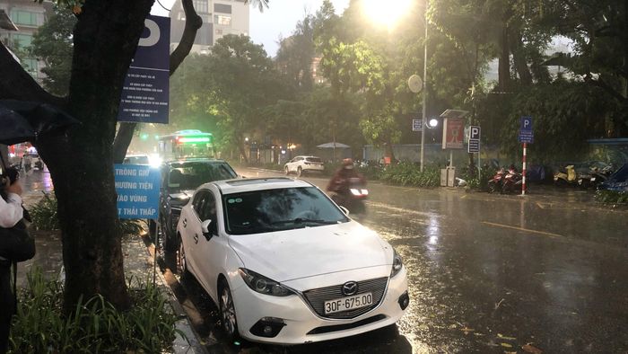 Trung tâm Hà Nội mưa to, trời tối sầm. Ảnh: PHÚC HẬU