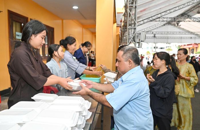 Người dân, Phật tử nhận cơm chay miễn phí tại Việt Nam Quốc Tự trong Lễ Vu Lan. Ảnh: MẠNH THẮNG