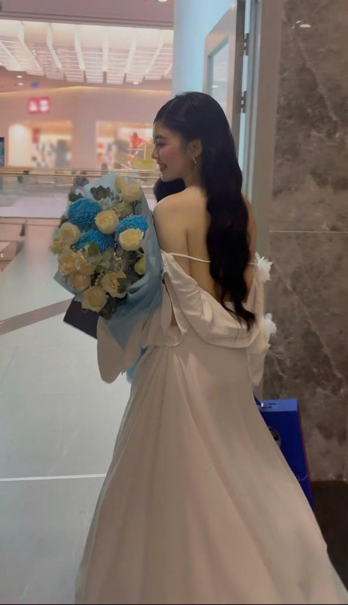 Váy trắng hở lưng với chi tiết nơ lớn phía sau cho thấy lựa chọn thời trang gợi cảm của Lọ Lem. Cô để tóc đen dài buông tự nhiên, hạn chế trang sức. Lối trang điểm nhẹ cùng làn da sáng giúp tổng thể vẫn giữ nét trẻ trung. (Ảnh: FB Mai Thảo Linh)