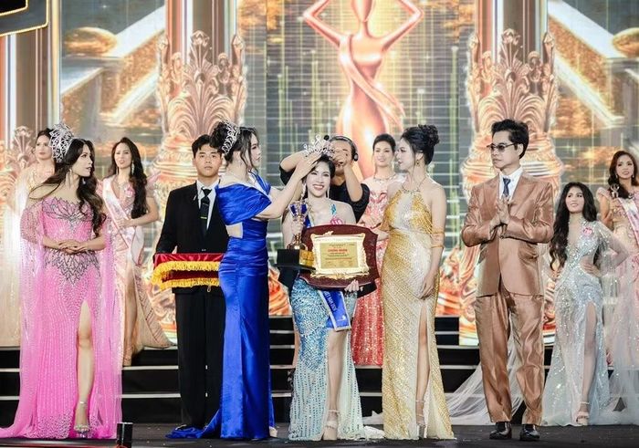 Hoa hậu Đại sứ của cuộc thi Hoa hậu Doanh nhân Hương sắc Việt Nam 2026 – Trần Thị Quỳnh Thơm nhận vương miện, dải băng sash danh hiệu, cúp lưu niệm và bằng chứng nhận. (Ảnh: Team Bình Nguyễn)