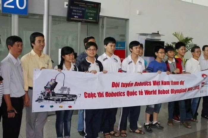 Thầy Hoàng Đăng Quang (áo vàng) và em Hương Giang (thứ 3 từ trái sang) trong đợt thi quốc tế mùa Robotacon 2013.