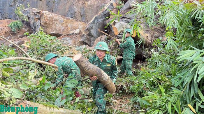 Cán bộ, chiến sĩ Đồn Biên phòng Chiềng Tương dọn dẹp cây cối, đất đá bị đổ chắn ngang đường. Ảnh: Quàng Hùng