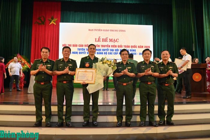 Thiếu tướng Vũ Quốc Ân (thứ ba từ phải sang), Thiếu tướng Văn Ngọc Quế (thứ hai từ trái sang) tặng hoa chúc mừng Thiếu tá Vũ Lý Huỳnh. Ảnh: Trương Tùng