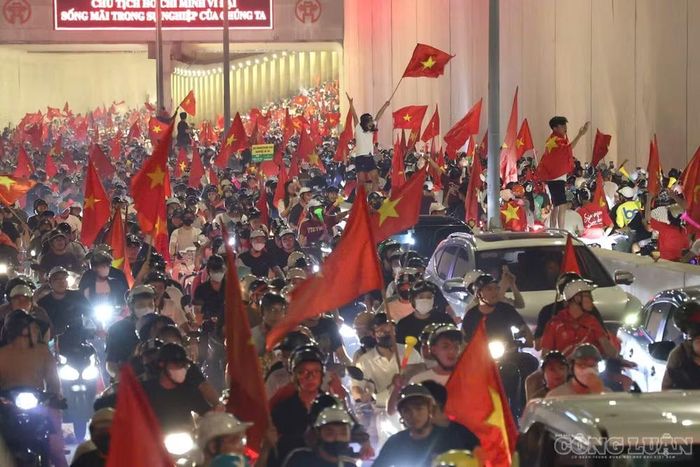 Trong hầm, các cổ động viên nhích từng chút một giữa dòng người, cùng hò reo, vẫy cờ và chia sẻ niềm vui chiến thắng.
