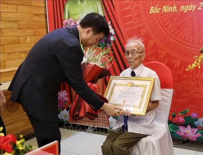 Ông Nguyễn Duy Ngọc, Ủy viên Bộ Chính trị, Bí thư Trung ương Đảng, Trưởng ban Tổ chức Trung ương, trao tặng Huy hiệu 80 năm tuổi Đảng cho đồng chí Nguyễn Thanh Mậu. Ảnh: TTXVN