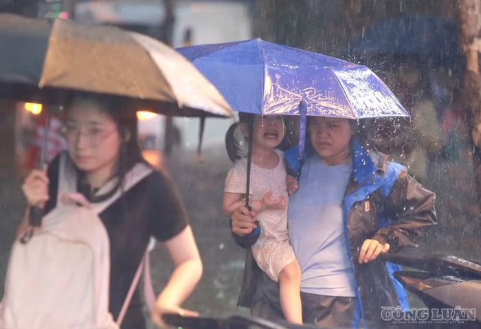 Nhiều gia đình phải bế con nhỏ vừa đón từ trường, lội qua những đoạn đường ngập để về nhà.