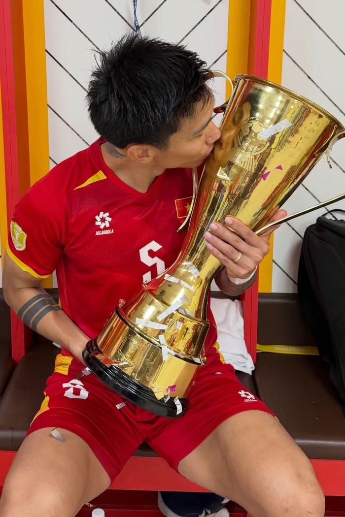 Đoàn Văn Hậu ôm và hôn chiếc cúp ASEAN Cup trong phòng thay đồ sau khoảnh khắc đăng quang của tuyển Việt Nam. Hậu vệ sinh năm 1999 góp mặt trong hành trình tuyển Việt Nam vượt qua Thái Lan với tổng tỷ số 4-2 sau hai lượt trận chung kết.