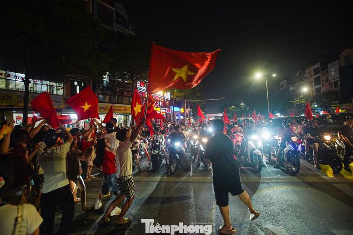 Trong lúc các phương tiện dừng chờ đèn đỏ, nhiều người đi bộ tranh thủ xuống đường hòa vào không khí ăn mừng.