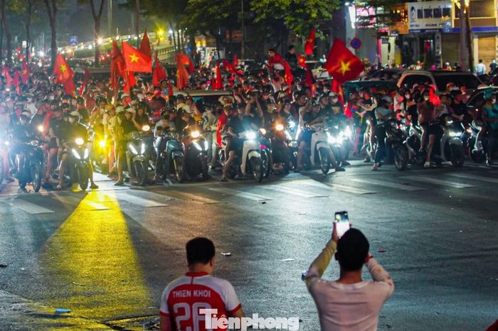 Tại nút giao trên phố Tây Sơn, đoàn xe cổ vũ tuyển Việt Nam dừng kín mặt đường nhưng vẫn chờ đèn xanh trước khi tiếp tục hành trình.