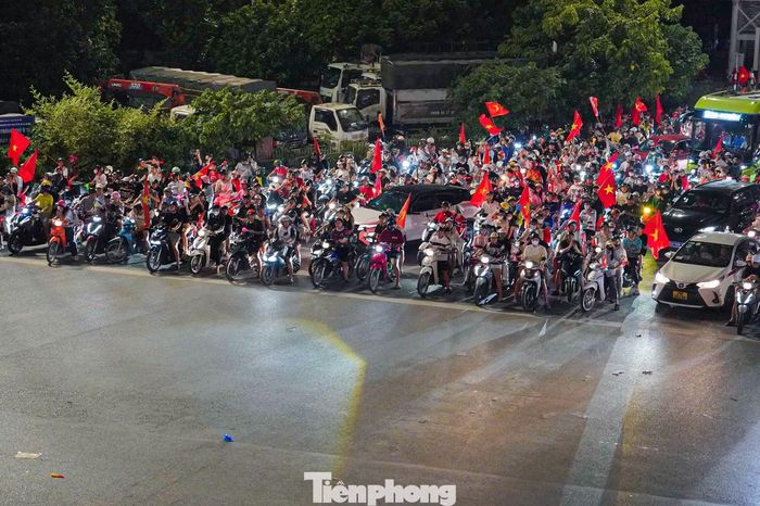 Giữa không khí ăn mừng cuồng nhiệt, hàng dài phương tiện vẫn dừng ngay ngắn khi đèn tín hiệu chuyển đỏ tại nút giao Mai Dịch - Vành đai 3.