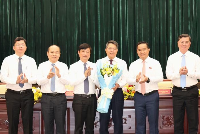 Chủ tịch HĐND TPHCM Võ Văn Minh (thứ 3 từ trái qua), Chủ tịch UBND TPHCM Nguyễn Văn Được (thứ hai từ trái qua) trao hoa chúc mừng ông Lê Văn Thăng. Ảnh: Ngô Tùng