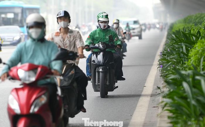 Trên đường Phạm Hùng, một trong những trục giao thông lớn ở phía Tây Thủ đô, lượng phương tiện đông từ đầu giờ sáng. Ánh sáng yếu xuyên qua lớp không khí đục, khiến toàn cảnh tuyến đường trở nên mờ nhòe.