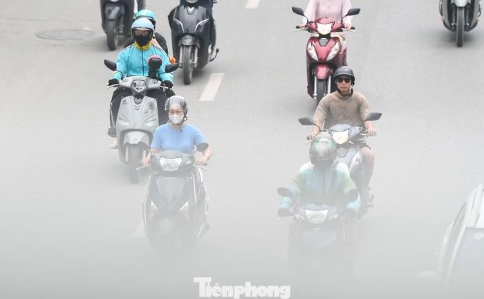 Dòng phương tiện di chuyển trên Đại lộ Thăng Long giữa lớp không khí trắng xám.