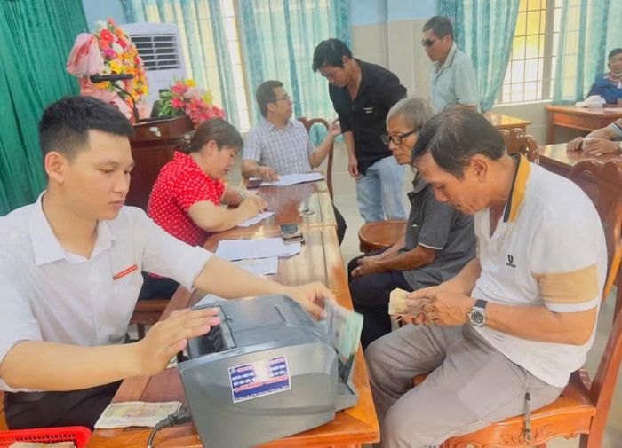 Người dân nhận tiền hỗ trợ thiệt hại. Ảnh: Xã Thanh Sơn