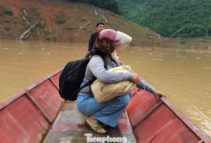 Giáo viên phải ngồi thuyền để vượt lòng hồ.