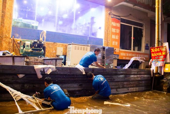 Một số hộ dân phải tát nước, làm vách chắn để ngăn nước tràn vào tầng hầm các căn nhà liền kề.
