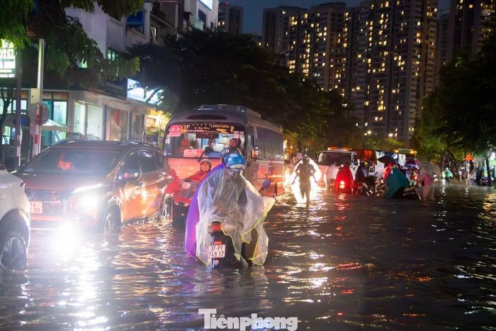  Dòng phương tiện kéo dài, dừng chờ cứu hộ và nhích từng mét qua điểm ngập sâu. 