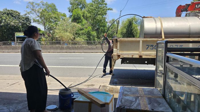 Người dân đặt các vật dụng trước nhà để chờ xe bồn tiếp nước.