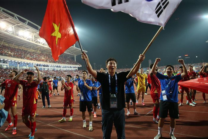 Sau trận đấu, HLV Kim Sang Sik cầm cờ Việt Nam và Hàn Quốc đi tới các khán đài cảm ơn CĐV.