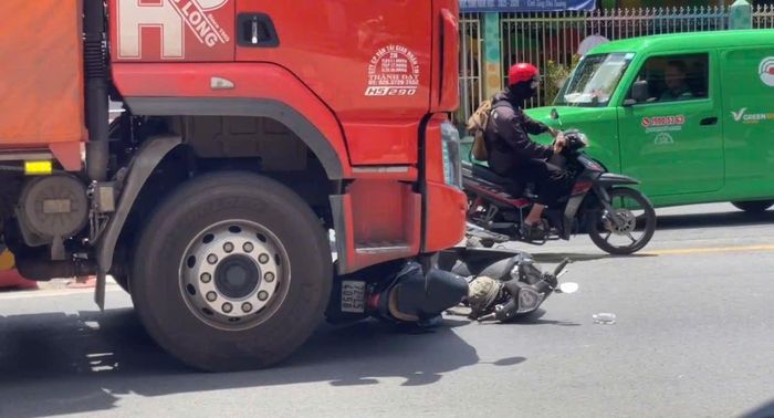 Xe máy kẹt cứng trước đầu xe tải. Ảnh: TK