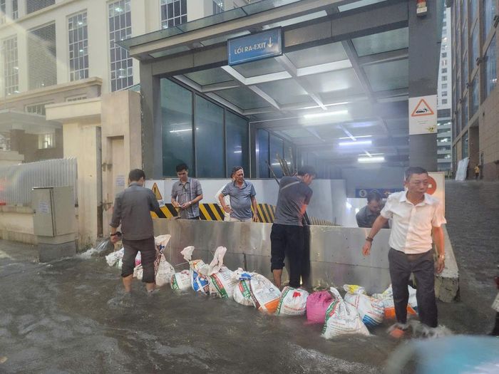 Người dân đang ngăn nước tràn vào một chung cư ở phường Cầu Giấy. Ảnh: T.T.