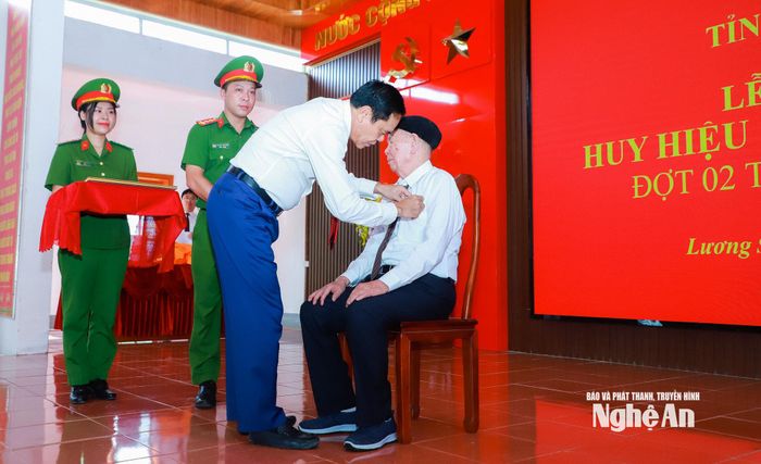 Chủ tịch UBND tỉnh Võ Trọng Hải gắn Huy hiệu 80 năm tuổi Đảng cho đảng viên Hoàng Ngọc Túy. Ảnh: Thành Duy