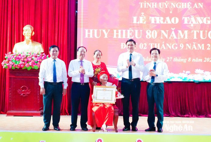 Các đồng chí lãnh đạo tỉnh và xã Đức Châu tặng hoa chúc mừng đảng viên Cao Thị Niêm, sinh hoạt tại Chi bộ Vạn Phú, xã Đức Châu. Ảnh: Mai Hoa