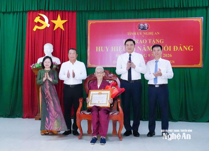 Các đồng chí lãnh đạo tỉnh và xã Quỳnh Thắng tặng hoa chúc mừng đảng viên Hồ Quang Toản, sinh hoạt tại Chi bộ Bến Nghè, xã Quỳnh Thắng. Ảnh: Mai Hoa