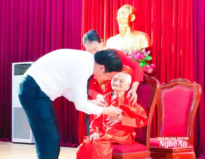 Đồng chí Hoàng Nghĩa Hiếu - Phó Bí thư Thường trực Tỉnh ủy, Chủ tịch HĐND tỉnh trao Huy hiệu 80 năm tuổi Đảng đến đảng viên Cao Thị Niêm, sinh hoạt tại Chi bộ Vạn Phú, xã Đức Châu. Ảnh: Mai Hoa