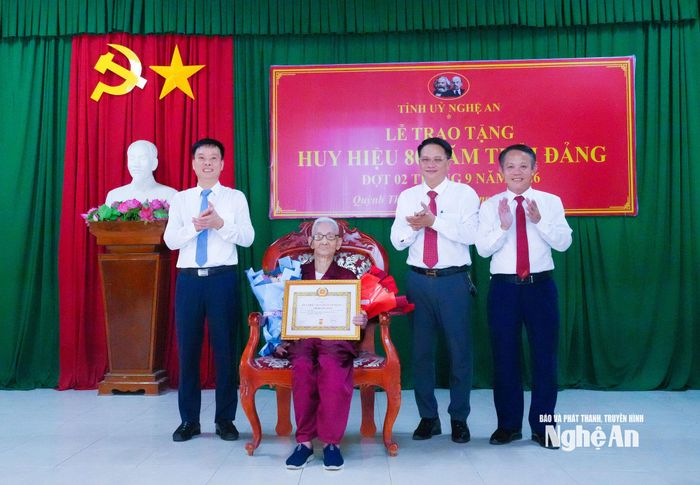 Lãnh đạo xã Quỳnh Thắng tặng hoa chúc mừng đảng viên Hồ Quang Toản, sinh hoạt tại Chi bộ Bến Nghè, xã Quỳnh Thắng. Ảnh: Mai Hoa.