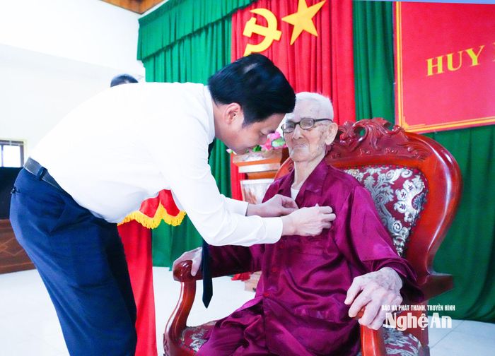 Đồng chí Hoàng Nghĩa Hiếu - Phó Bí thư Thường trực Tỉnh ủy, Chủ tịch HĐND tỉnh trao Huy hiệu 80 năm tuổi Đảng đến đảng viên Hồ Quang Toản, sinh hoạt tại Chi bộ Bến Nghè, xã Quỳnh Thắng. Ảnh: Mai Hoa