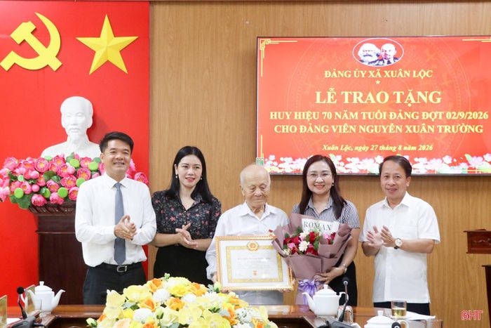 Lãnh đạo tỉnh, lãnh đạo địa phương chụp ảnh lưu niệm cùng đảng viên Nguyễn Xuân Trường.