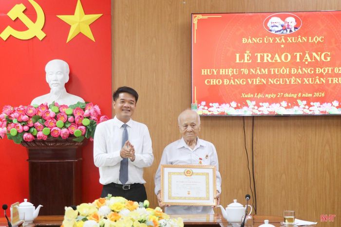 Đồng chí Trần Nhật Tân - Ủy viên Ban Thường vụ, Trưởng ban Nội chính Tỉnh ủy trao Huy hiệu 70 năm tuổi Đảng cho đồng chí Nguyễn Xuân Trường.