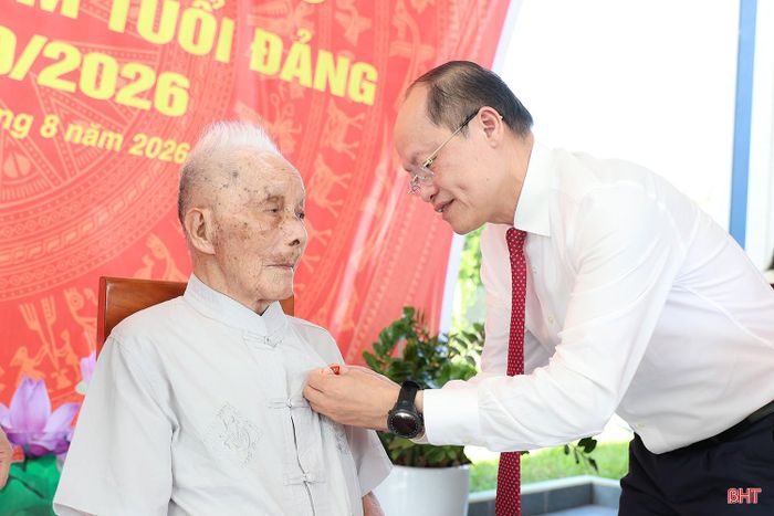 Đồng chí Nguyễn Hồng Lĩnh - Phó Bí thư Thường trực Tỉnh ủy, Chủ tịch HĐND tỉnh trao Huy hiệu 80 năm tuổi Đảng cho đồng chí Đặng Tưng.