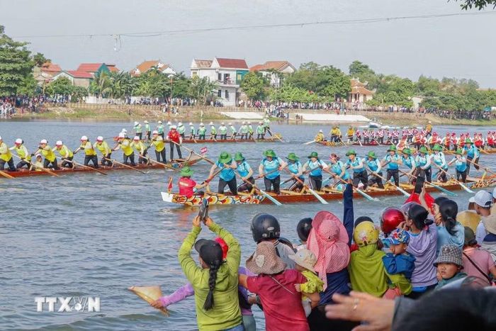 Người dân cổ vũ các đội thuyền đua nữ tại Lễ hội đua thuyền truyền thống trên sông Kiến Giang (Quảng Trị). (Ảnh: TTXVN phát)