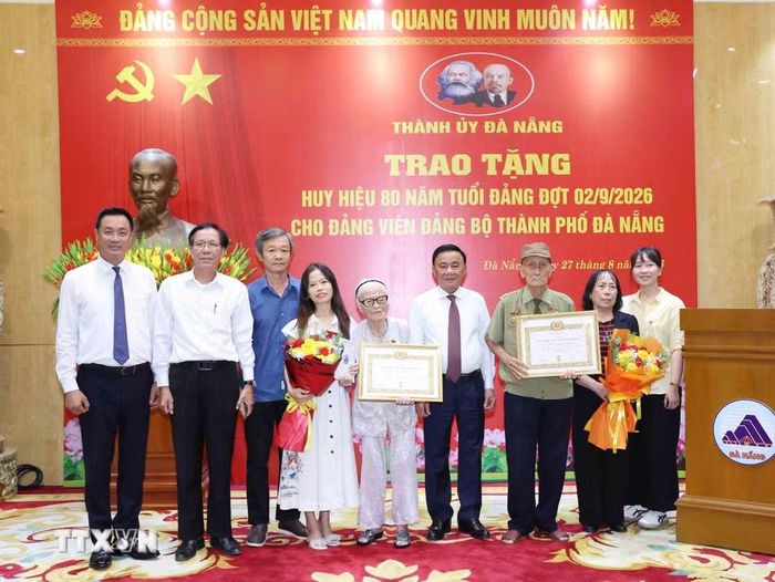 Thường trực Ban Bí thư Trần Cẩm Tú cùng gia đình đảng viên lão thành Nguyễn Thị Hữu và Hồ Văn Lang, Đảng bộ thành phố Đà Nẵng. (Ảnh: Phương Hoa/TTXVN)