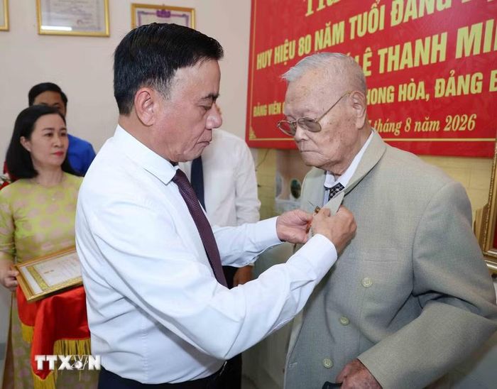 Thường trực Ban Bí thư Trần Cẩm Tú gắn Huy hiệu 80 năm tuổi Đảng cho đảng viên lão thành Lê Thanh Minh, phường Hội An, thành phố Đà Nẵng. (Ảnh: Phương Hoa/TTXVN) 