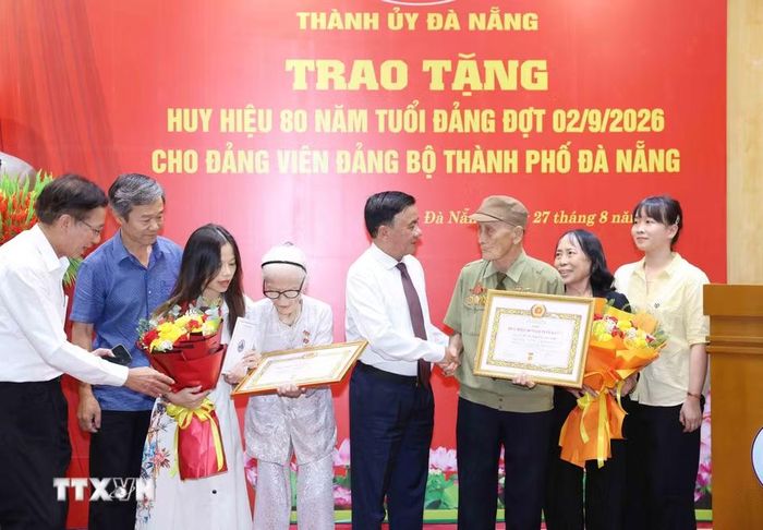 Thường trực Ban Bí thư Trần Cẩm Tú cùng gia đình đảng viên lão thành Nguyễn Thị Hữu và Hồ Văn Lang, Đảng bộ thành phố Đà Nẵng. (Ảnh: Phương Hoa/TTXVN)