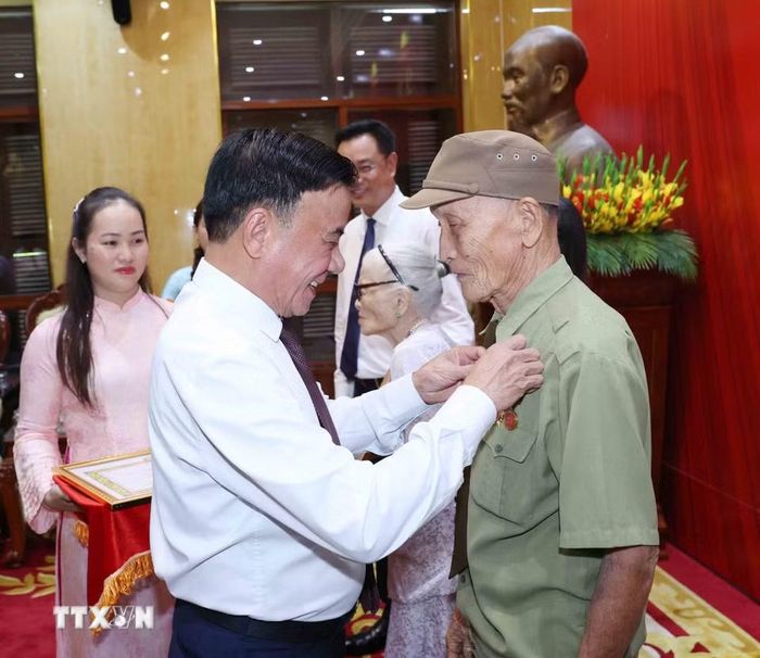 Thường trực Ban Bí thư Trần Cẩm Tú trao Huy hiệu 80 năm tuổi Đảng cho đảng viên lão thành Hồ Văn Lang. (Ảnh: Phương Hoa/TTXVN)