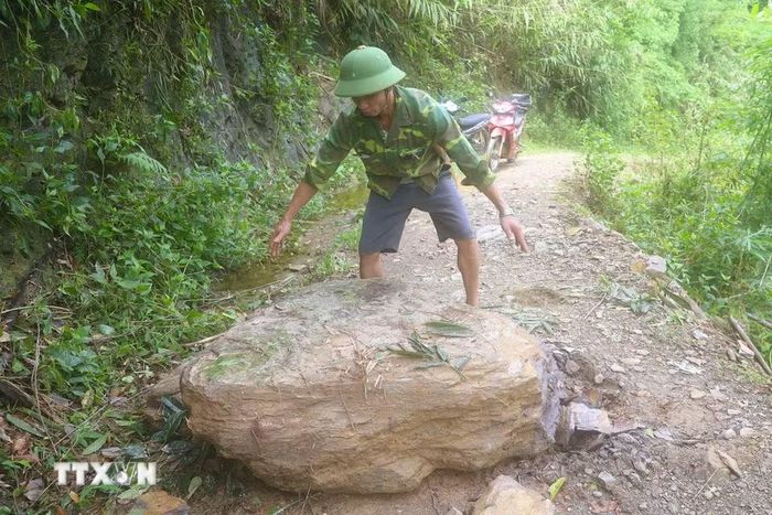 Một tảng đá lớn lăn từ trên núi xuống nằm án ngữ trên mặt đường tại đoạn tuyến dốc Co Pọng-dốc Hin Nam trên tuyến đường Xốp Kho-Na Ngân (xã Nga My, tỉnh Nghệ An). (Ảnh: Xuân Tiến/TTXVN)